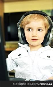 Beautiful little girl in ear-phones listens to music