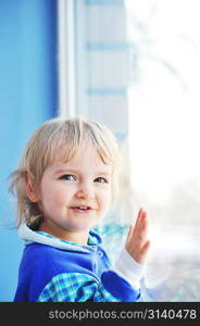 Beautiful little girl is by window portrait