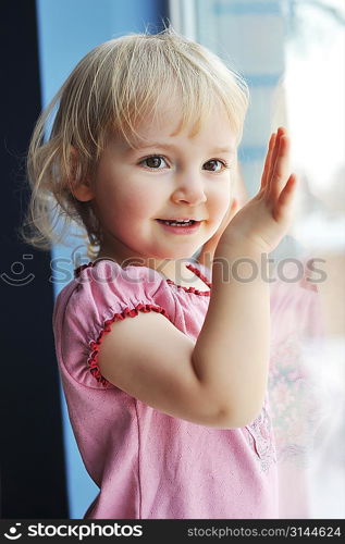 Beautiful little girl is by window portrait