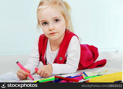 Beautiful little girl is drawing on paper