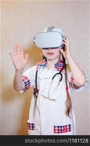 Beautiful little girl is playing dressed doctor. Girl plays virtual reality, children&rsquo;s role profession doctor. Early development of the child, ideas for the game.. Beautiful little girl is playing dressed doctor.