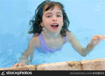 beautiful little girl smiling in pool blue water