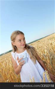 Beautiful little girl standing in wheat field