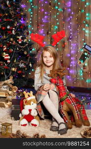 Beautiful Little girl waiting for a miracle in Christmas decorations