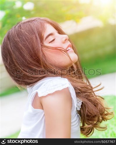 Beautiful little girl with closed eyes meditating in the park, doing yoga exercises outdoors, healthy lifestyle, zen balance, peace and soul harmony concept