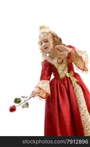 Beautiful little girl with long blonde hair in the princess costume using a red rose like a magic wand at the white background. Red and gold empire dress