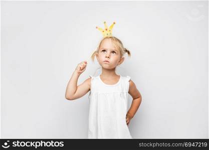 Beautiful little girl with paper crown posing on white backgroun. Beautiful little girl with paper crown posing on white background at home