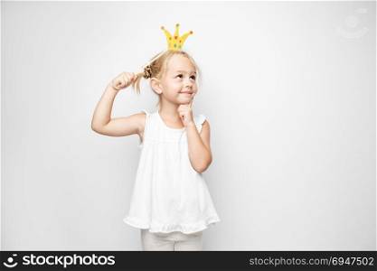 Beautiful little girl with paper crown posing on white background at home. Beautiful little girl with paper crown posing on white backgroun