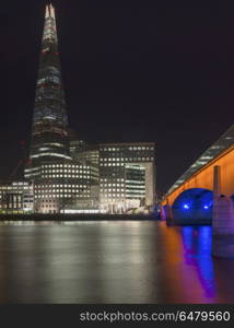 Beautiful London City skyline landscape at night with glowing ci. England, London, London Bridge. The Shard and London Bridge in London at night.. Stunning London City skyline landscape at night with glowing city lights and iconic landmark buldings and locations