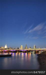 Beautiful London City skyline landscape at night with glowing ci. England, London, South Bank. View along River Thames at night of London city skyline.. Stunning London City skyline landscape at night with glowing city lights and iconic landmark buldings and locations