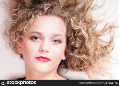 beautiful long blond curly hair of young attractive woman to lie