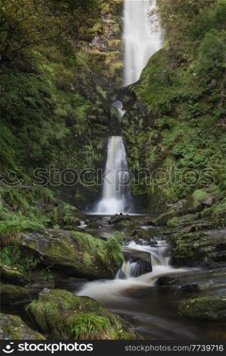 Beautiful long exposure landscape early Autumn image of Pistyll Rhaeader waterfall in Wales, the tallest waterfall in UK