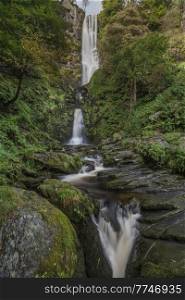 Beautiful long exposure landscape early Autumn image of Pistyll Rhaeader waterfall in Wales, the tallest waterfall in UK