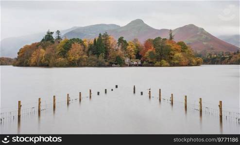 Beautiful long exposure landscape image of Derwentwater looking towards Catbells peak in Autumn during early morning