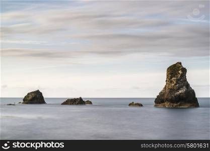 Beautiful long exposure peaceful landscape of rocks in sea