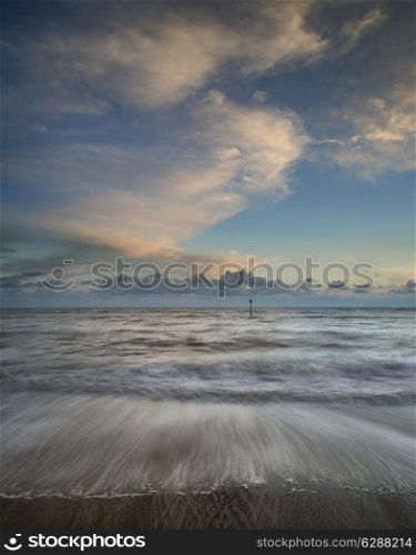 Beautiful long exposure vibrant conceptual image of ocean at sunset