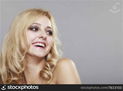 Beautiful long hair fashion blonde girl, young happy smiling woman portrait. Elegant lady on gray background.