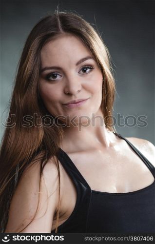 Beautiful long hair girl in sportwear young woman portrait on gray background.