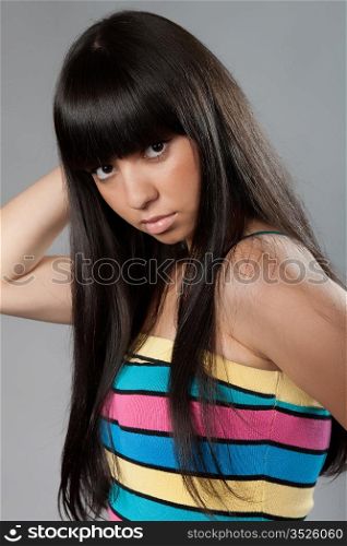 beautiful long-haired girl on a grey background