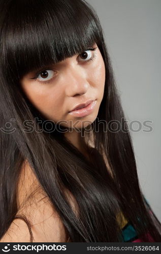 beautiful long-haired girl on a grey background