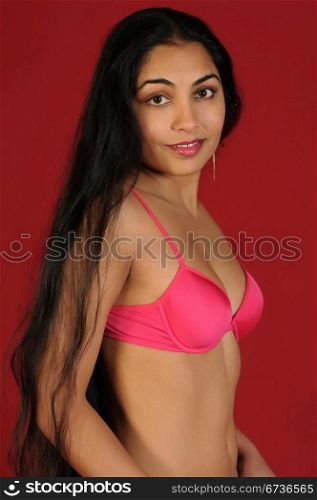 Beautiful long haired Indian woman in pink lingerie