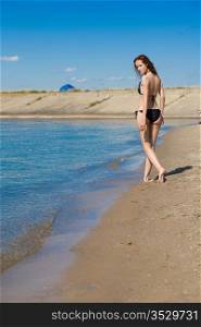 Beautiful long-legged girl on a sandy beach