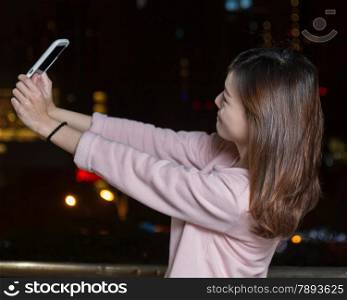 Beautiful Malaysian female with bright lights of city in background