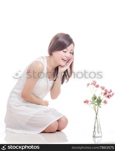 Beautiful Malaysian woman looking at pink flowers in a vase