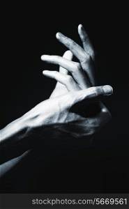 beautiful male hands in silver paint on black background
