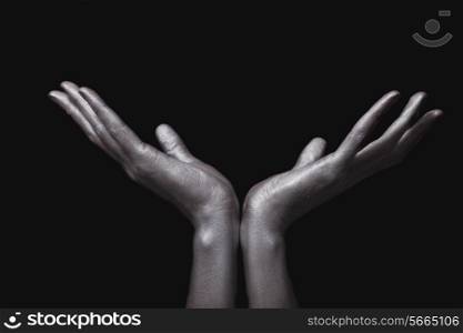 beautiful man&rsquo;s hands in silver paint on black background