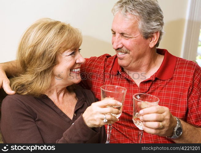 Beautiful mature couple enjoying a glass of wine and gazing into each others eyes.