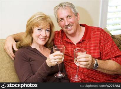 Beautiful mature couple enjoying a glass of wine together at home.