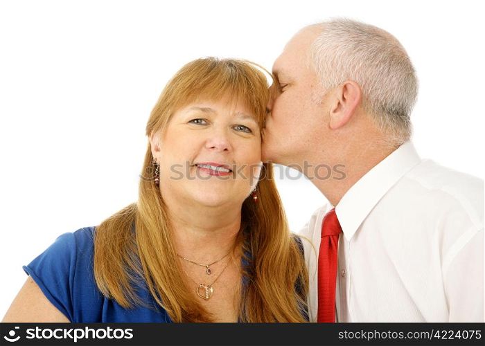 Beautiful mature woman receiving a kiss on the cheek from her husband. Isolated on white.