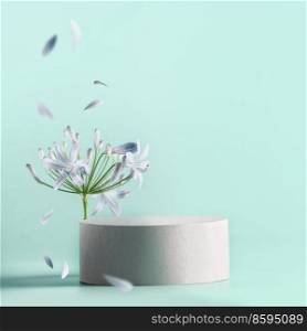 Beautiful minimal  modern product display with podium with flower bloom with flying petals at pale blue background. Place for beauty products or marketing c&agne. Front view.