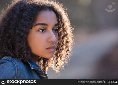 Beautiful mixed race African American girl teenager female young woman outside by a road looking sad depressed or thoughtful