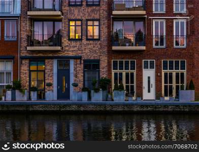beautiful modern dutch city architecture at night, terraced houses at the canal with balconies, Alphen aan den Rijn, The Netherlands