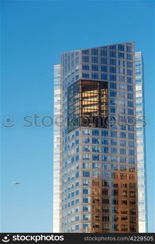 Beautiful modern office building and airplane against the blue sky
