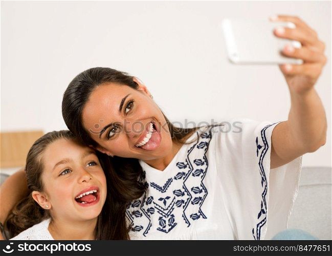 Beautiful Mom and Daughter at home making a selfie