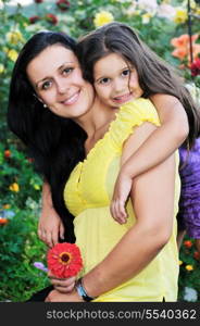 beautiful mom and daughter outdoor in garden together with flower have fun and hug