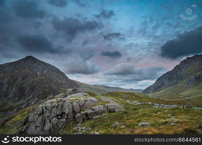 Beautiful moody landscape image of Nant Francon valley in Snowdonia during sunset in Autumn