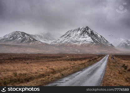 Beautiful moody Winter landscape image of Lost Valley Etive Mor in Scottish Highlands wirth dramatic clouds overhead