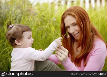 beautiful mother and baby little girl outdoor park garden grass playing