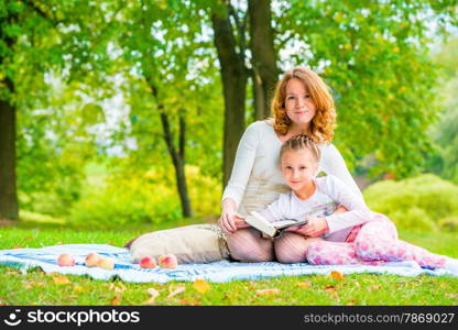 Beautiful mother and daughter spend a weekend at a picnic in the park