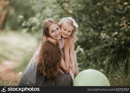 Beautiful Mother And her little daughter outdoors. Nature. Beauty Mum and her Child playing in Park together. Outdoor Portrait of happy family. Happy Mother&rsquo;s Day Joy. Mom and Baby