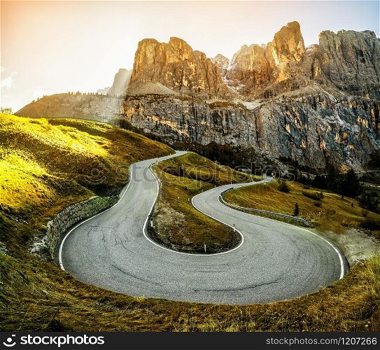 Beautiful mountain road with trees, forest and mountains in the backgrounds. Taken at state highway road in Passo Gardena, Sella mountain group of Dolomites mountain in Italy.
