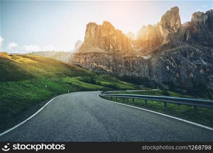 Beautiful mountain road with trees, forest and mountains in the backgrounds. Taken at state highway road in Passo Gardena, Sella mountain group of Dolomites mountain in Italy.