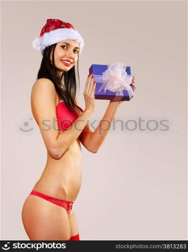 Beautiful mrs claus with gift wearing in red bikini costume isolated