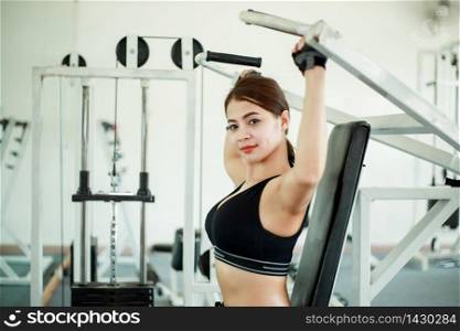 beautiful muscular fit woman asian exercising building muscles and fitness woman doing exercises in the gym. Fitness - concept of healthy lifestyle,soft focus