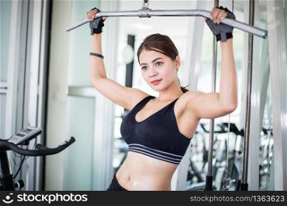 beautiful muscular fit woman exercising building muscles and fitness woman doing exercises in the gym. Fitness - concept of healthy lifestyle
