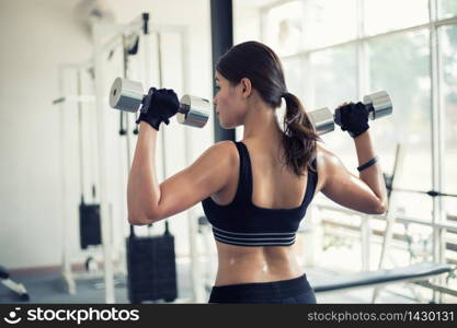 beautiful muscular fit woman exercising building muscles and fitness woman doing exercises in the gym. Fitness - concept of healthy lifestyle,soft focus